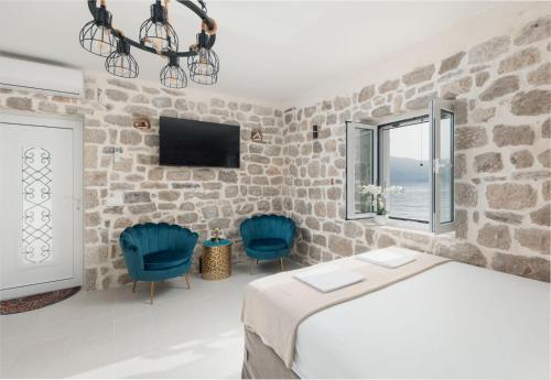 a bedroom with a bed and two blue chairs at Stone sea apartment in Risan