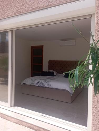 - une chambre avec un lit accessible par une porte coulissante en verre dans l'établissement Chambre & plage & Spa & Piscine & wifi, à Valras-Plage