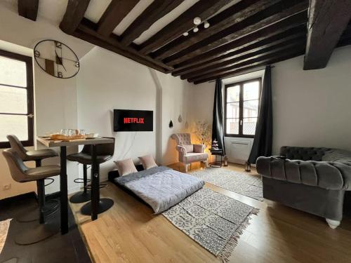 ein Wohnzimmer mit Tisch und Couch in der Unterkunft Nid de Montereau - Centre - 4 personnes in Montereau-faut-Yonne