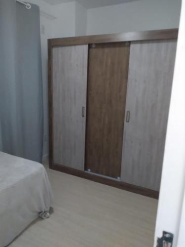 a bedroom with two sliding glass doors and a bed at Sobrado 500mts Shooping in Joinville