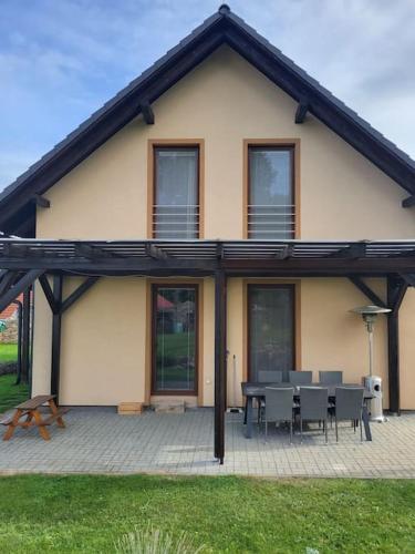 a house with a patio with a table and chairs at Vysočina, Fryšava 199 - Chalupa pod kopcem in Fryšava