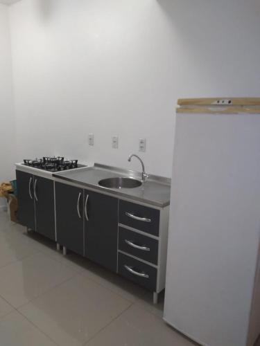 a kitchen with a sink and a refrigerator at Sobrado 500mts Shooping in Joinville