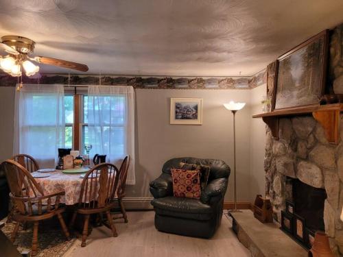 een woonkamer met een tafel, een stoel en een open haard bij Lake Congamond Suffield House in Granby