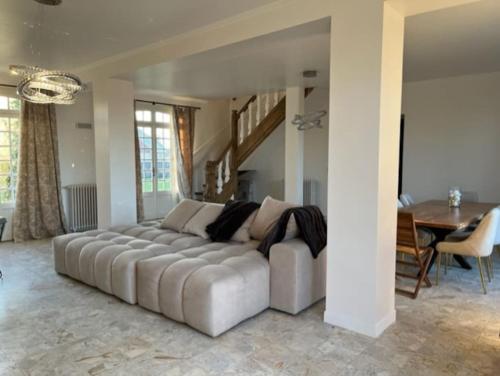 - un grand canapé dans le salon avec une table dans l'établissement La Villa Bourgeoise, à Croisilles