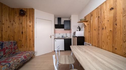 Cette chambre dispose d'une table, d'un canapé et d'une cuisine. dans l'établissement LE SCHUSS 5 - 28 Studio cabine 4 pers, à La Foux