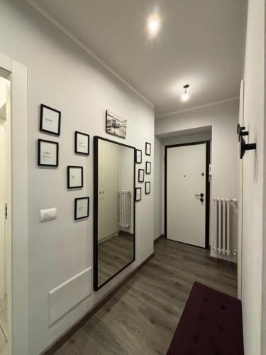 a hallway with a mirror on a wall with pictures at Casa Florian in Turin
