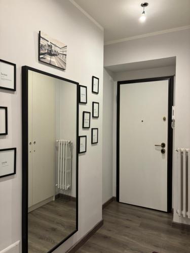 a hallway with a mirror and a white door at Casa Florian in Turin