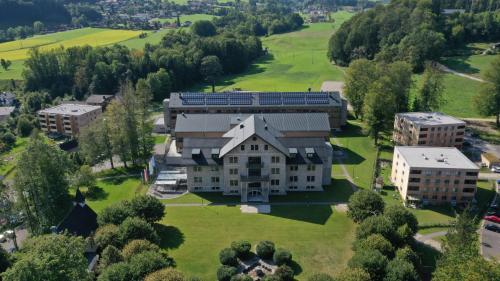 una vista aerea di un grande edificio su un campo verde di Waldcampus Österreich a Traunkirchen