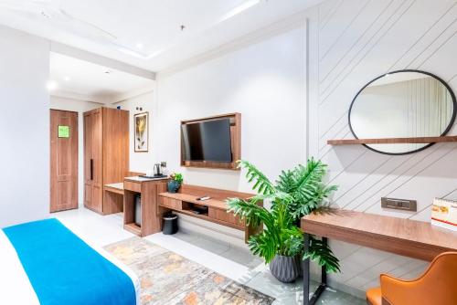 a bedroom with a blue bed and a mirror at Pride Comfort Dwarka Near Dwarkadhish Temple in Dwarka