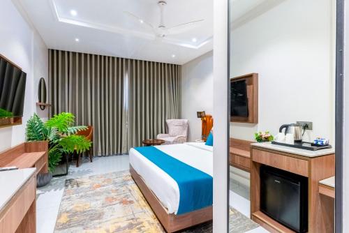 a hotel room with a bed and a kitchen at Pride Comfort Dwarka Near Dwarkadhish Temple in Dwarka