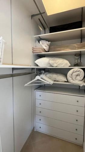 a white closet with white cabinets and white towels at Casa Colò in Naples
