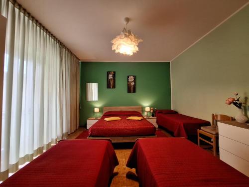 a bedroom with two red beds and a green wall at Bed & Breakfast "Il Ghiro" in San Martino sulla Marruccina