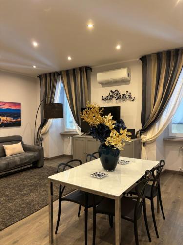 a living room with a table with a vase of flowers on it at Casa Florian in Turin
