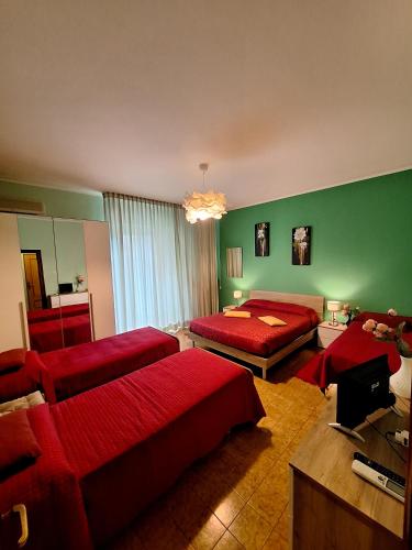 a bedroom with red beds and a green wall at Bed & Breakfast "Il Ghiro" in San Martino sulla Marruccina