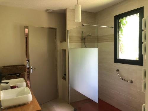 a bathroom with a glass shower and a sink at Aux Couleurs Miel in Montolieu