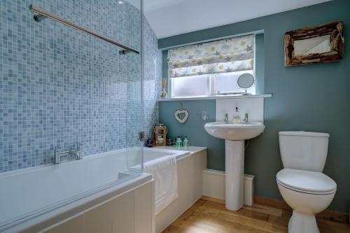 une salle de bain avec une baignoire, des toilettes et un lavabo dans l'établissement Natterjack by Winterton Cottages, à Winterton-on-Sea