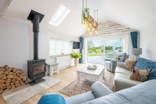 a living room with a couch and a fireplace at The Cow Stalls - Stunning Farmhouse with Wonderful Views and Garden - Close to Corfe Castle in Langton Matravers