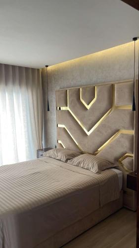a bedroom with a large bed with a gold headboard at Appartement vue sur Tower Hassan in Rabat