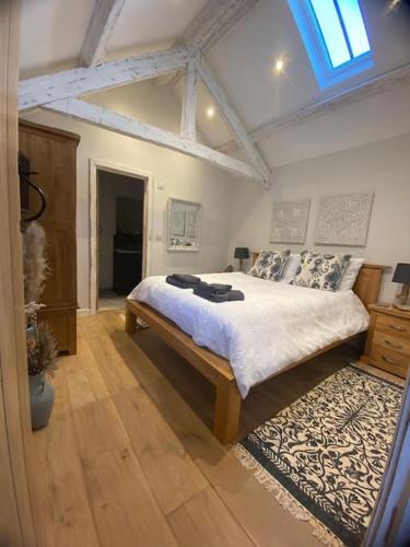 a bedroom with a large bed in a room at The Cow Stalls - Stunning Farmhouse with Wonderful Views and Garden - Close to Corfe Castle in Langton Matravers