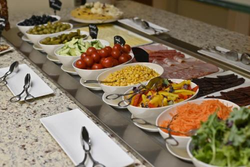 a buffet line with bowls of different types of food at Yerevan Place Hotel in Yerevan