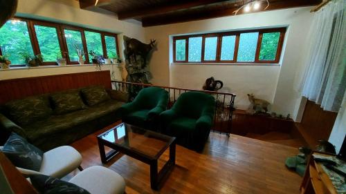 a living room with a couch and a table at Hamvaskői Vadászház in Pilismarót