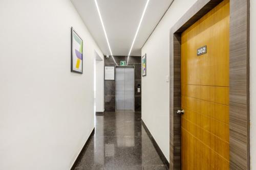 a hallway in a hospital with a wooden door at Treebo Sky City Grand, 5 Min From Mangalore Airport in Mangalore