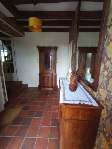 a living room with a table and a mirror at Villa le Roche du Ris - 10-12 personnes in Baraize