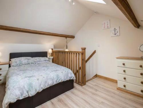 a bedroom with a bed and a dresser at Frondeg Bach in Tregaron