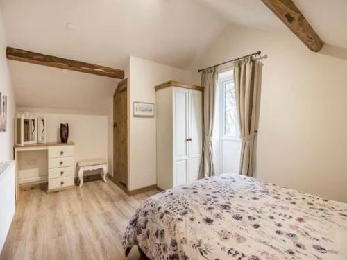 a bedroom with a bed and a dresser and a window at Frondeg Bach in Tregaron