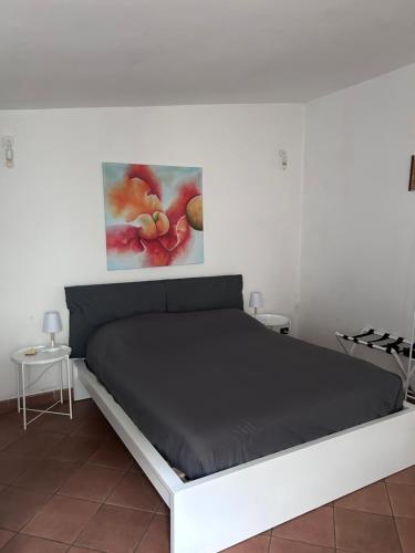 un letto in una stanza con un dipinto sul muro di B&B Uva Fragola a Perugia