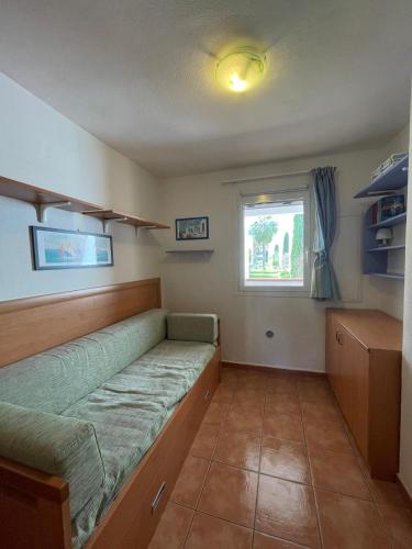 une petite pièce avec un lit et une fenêtre dans l'établissement Appartement T3 les pieds dans l'eau, à Moriani-Plage