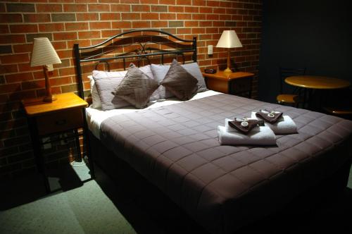 a bedroom with a bed with towels on it at Poachers Paradise in Rutherglen