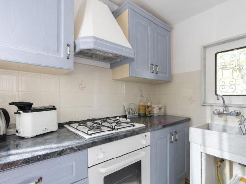 a kitchen with white cabinets and a stove top oven at Holiday Home Il Castagneto by Interhome in Taggia