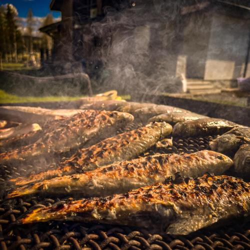 a bunch of sausages cooking on a grill at Chalet Deluț in Suceava
