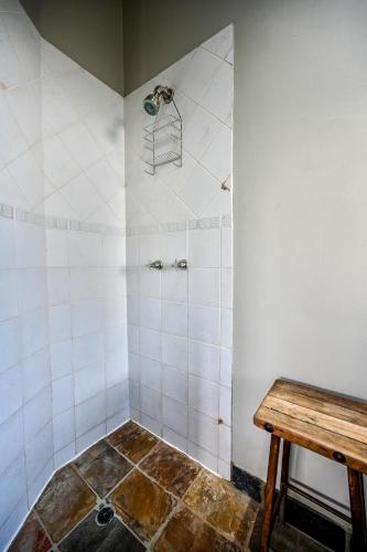a bathroom with a shower with a wooden table at Blue Rain Guest House in Bloemfontein