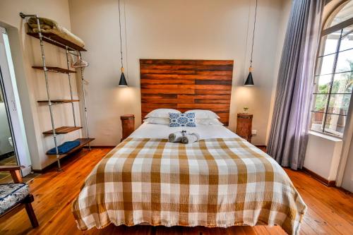 a bedroom with a bed with a checkered blanket at Blue Rain Guest House in Bloemfontein