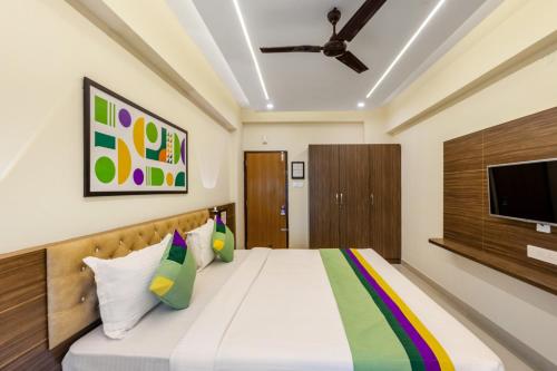 a bedroom with a bed with a tv on the wall at Treebo Sky City Grand, 5 Min From Mangalore Airport in Mangalore