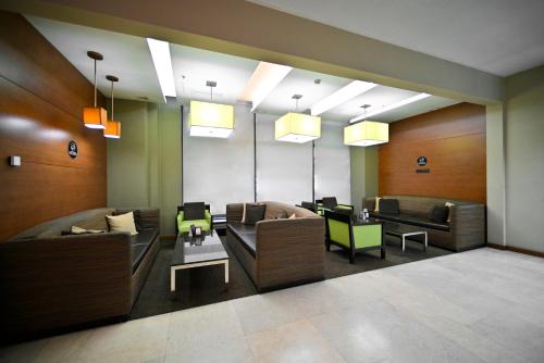 a lobby with couches and tables and lights at Yerevan Place Hotel in Yerevan