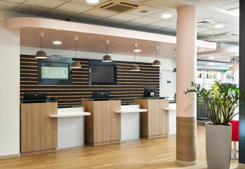 un bureau avec un hall d'entrée avec une télévision au mur dans l'établissement B&B HOTEL Orly Rungis Aéroport 3 étoiles, à Rungis