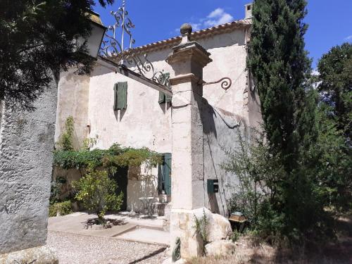 un vieux bâtiment avec une croix sur son côté dans l'établissement Location maison de campagne 5 personnes, à Quarante