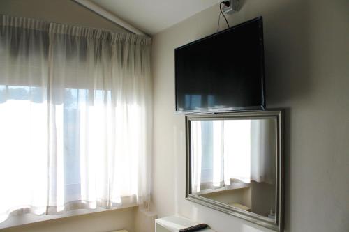 a room with a flat screen tv and a window at Oasi Santa Rosa in Rome