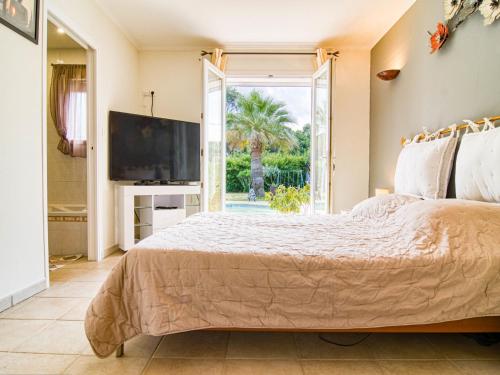 - une chambre avec un grand lit et une télévision dans l'établissement Holiday Home Villa Les Oliviers by Interhome, à Roquebrune-sur Argens