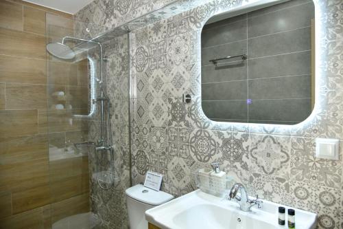 a bathroom with a sink and a mirror and a toilet at Captain theo apartment Annoula in Lefkímmi