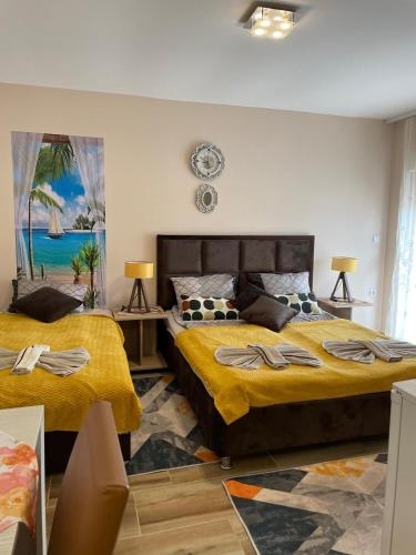 a bedroom with two beds and a clock on the wall at Apartmani Andrijana in Veliko Gradište