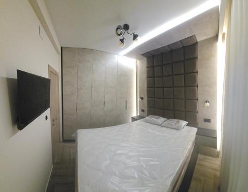 a bedroom with a white bed in a room at Deluxe Apartmani Vila Pejovic Sutomore in Sutomore