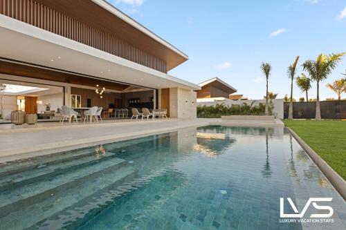 a swimming pool in the backyard of a house at Zen Oasis Villa at Casa de Campo in La Romana