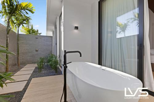a white bath tub in a bathroom with plants at Zen Oasis Villa at Casa de Campo in La Romana