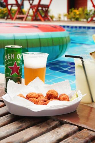 a plate of food and drinks on a table next to a pool at Pousada Camocim Beach in Camocim