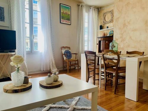 - un salon avec une table et des chaises blanches dans l'établissement Maison de ville au Cœur d'Angoulême- 2 chambres-Wifi- Cosy - Idéal de 1 à 6 Personnes - conciergerie J&N, à Angoulême