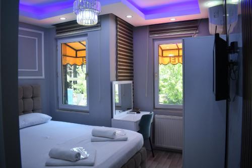 Un dormitorio con una cama, un escritorio y ventanas. en Modena Hotel, en Estambul